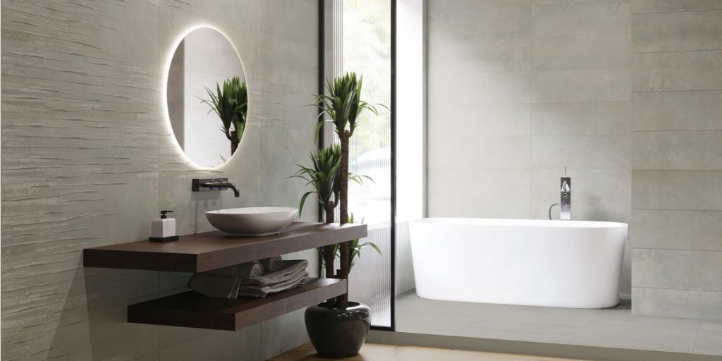 Стены ванной, облицованные серой керамикой, выглядят стильно и современно.