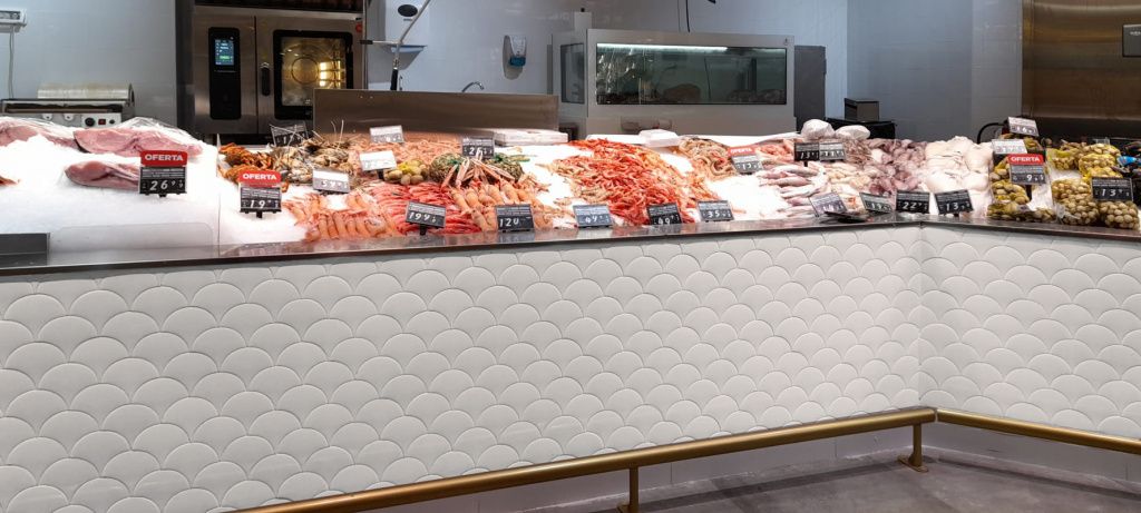 Для отделки фасада прилавка магазина морепродуктов выбрали белую плитку Squama